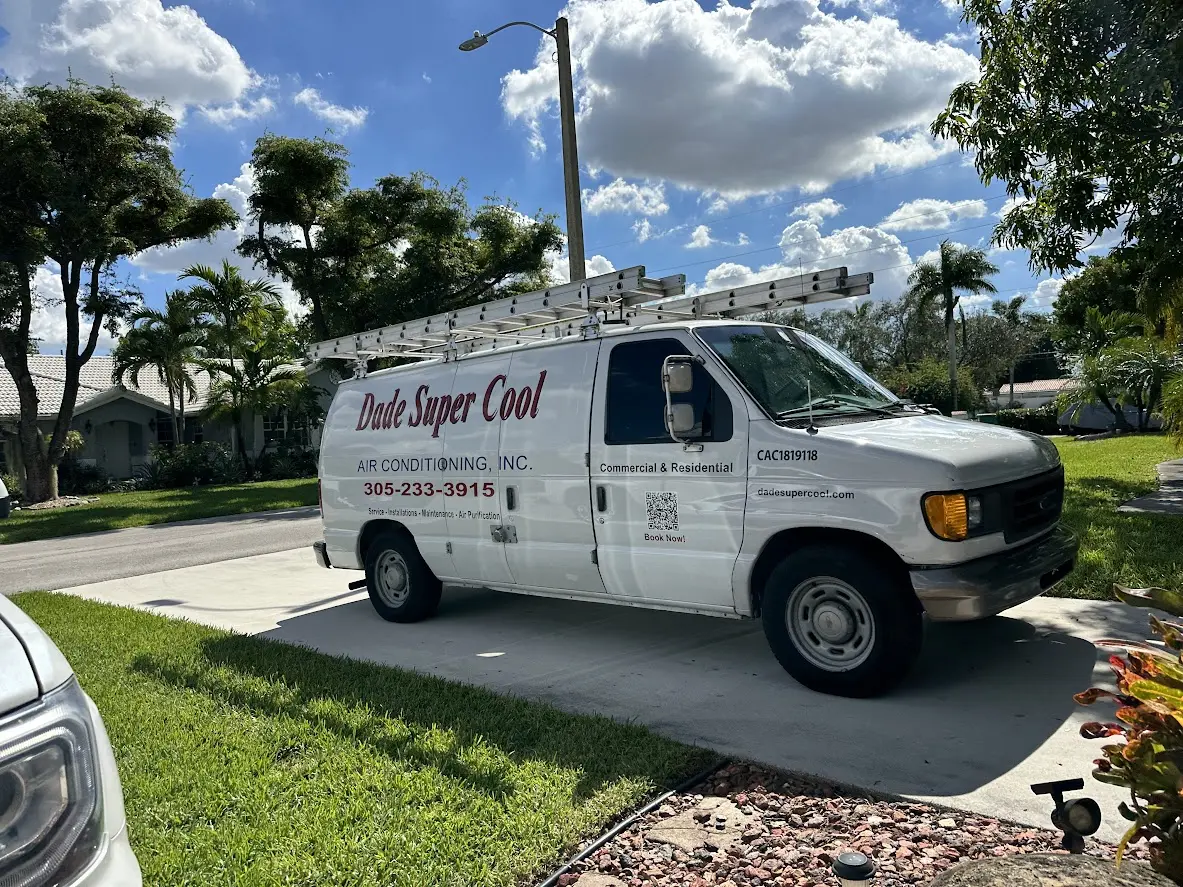A Dade Super Cool Air Conditioning service van with a roof ladder rack parked in the driveway of a Miami-Dade home